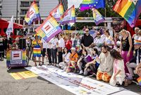 Auf dem Bild sind etwa zwanzig Menschen zu sehen, die hinter einem Banner stehen, auf dem "Vielfalt, Offenheit, Toleranz" steht. Einige haben Regenbogenfahnen mit dem Logo des Paritätischen in der Hand.