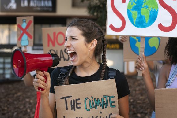 Eine Frau hält ein Megaphone und demonstriert für den Klimaschutz. Foto: freepik