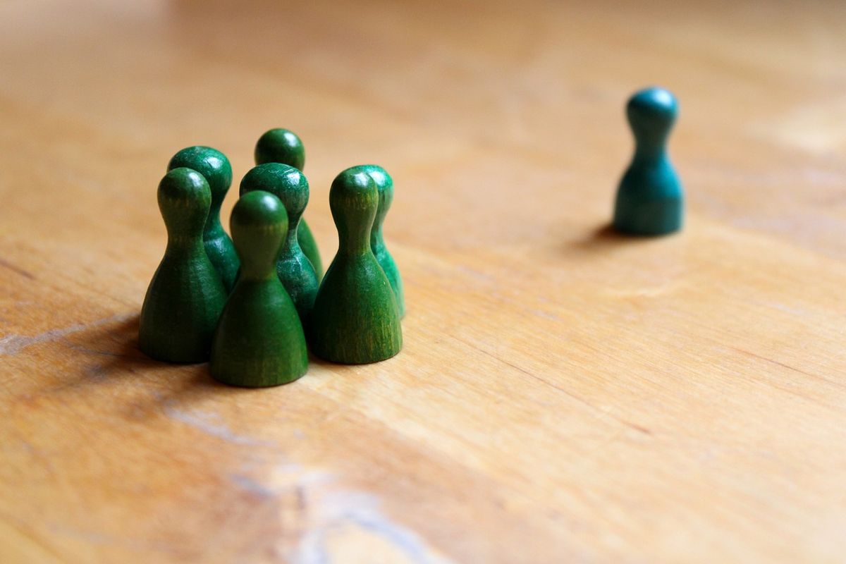 Links vier grüne Spielfiguren, rechts am Rand eine blaue Spielfigur.
