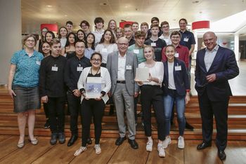 Foto: die ehemalige Schulklasse 9d des Duisburger Steinbart-Gymnasiums mit der Skulptur "Dialog und Toleranz"