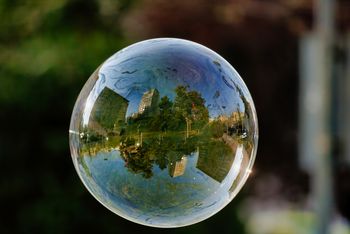In einer Seifenblase spiegeln sich Gebäude und Bäume. Bild von wirestock auf Freepik