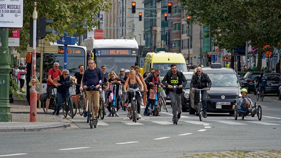 Eine Straße mit vielen nachhaltigen Verkehrsmitteln. Fahrräder, Busse, E-Roller