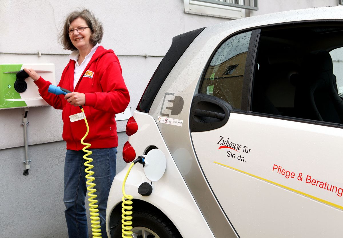 Renate de Fries Mitarbeiterin Renate de Fries lädt einen der E-Smarts aus der Flotte der Ambulanten Pflege des ASB Bremen auf.