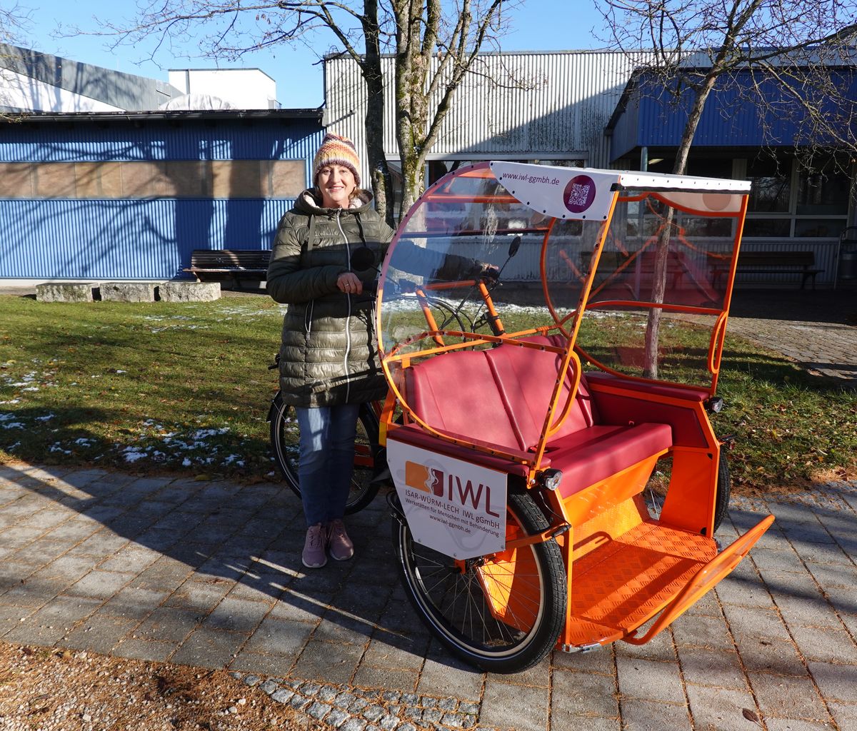 Das Bild zeigt eine Frau, die neben der Riksha steht