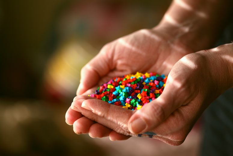 Eine Person hält viele kleine Sterne in der Hand, die alle unterschiedliche Farben haben.