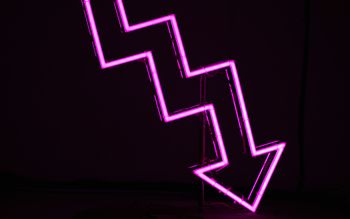 Ein pinker Pfeil vor schwarzem Hintergrund zeigt nach unten.