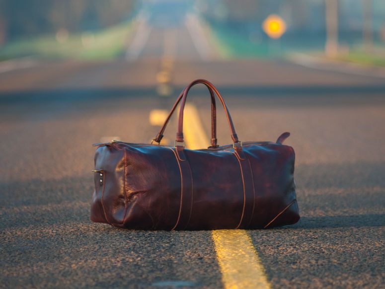 Eine Reisetasche steht auf einer Straße.