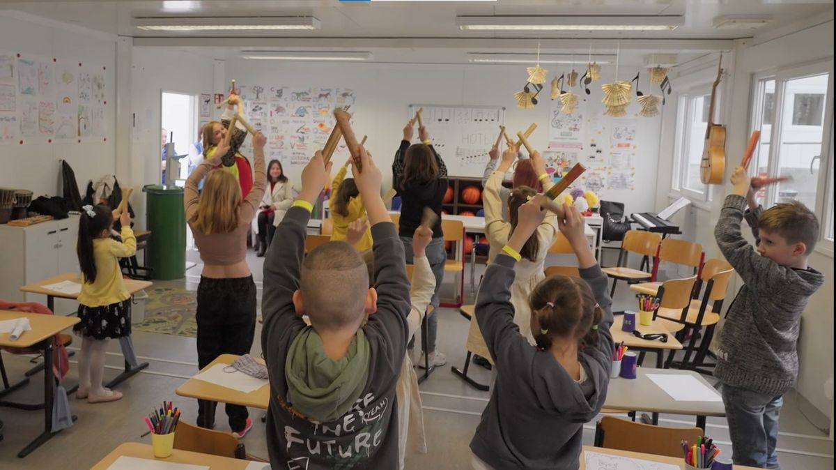Kinder von hinten beim musizieren mit Klangstöcken