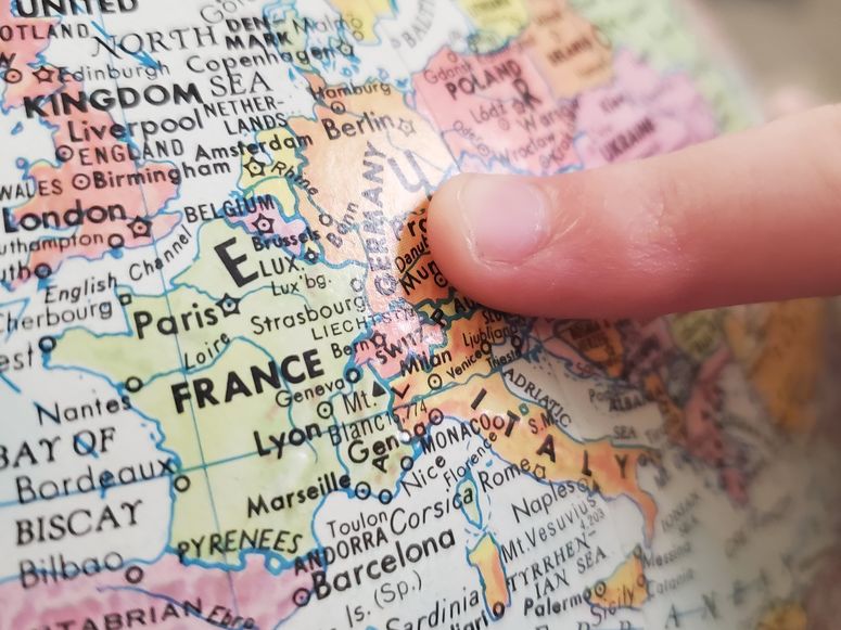 Ein Finger zeigt auf einem Globus auf Europa