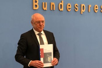 Zu sehen ist der Dr. Schneider mit dem Armutsbericht in der Hand