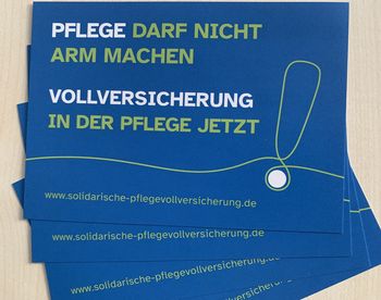 Auf blauem Hintergrund steht in großen Buchstaben "Pflege darf nicht arm machen, Vollversicherung in der Pflege jetzt". Am Ende des Textes steht ein großes Ausrufezeichen, das aus einem Faden gezeichnet ist.