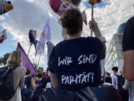 Eine Frau hält auf einer Demonstration in der Schild in der Hand, auf ihrem T-Shirt steht "Wir sind Parität".