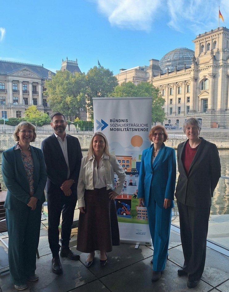 Ein Foto von einigen der Teilnehmenden des parlamentarischen Frühstücks vor dem Roll-Up des Bündnisses, mit dem Bundestag und der Spree im Hintergrund. Von links nach rechts: Christiane Rohleder (VCD), Frederik Moch (DGB), Verena Bentele (VdK), Katja Kipping (Paritätischer), Verena Graichen (BUND)