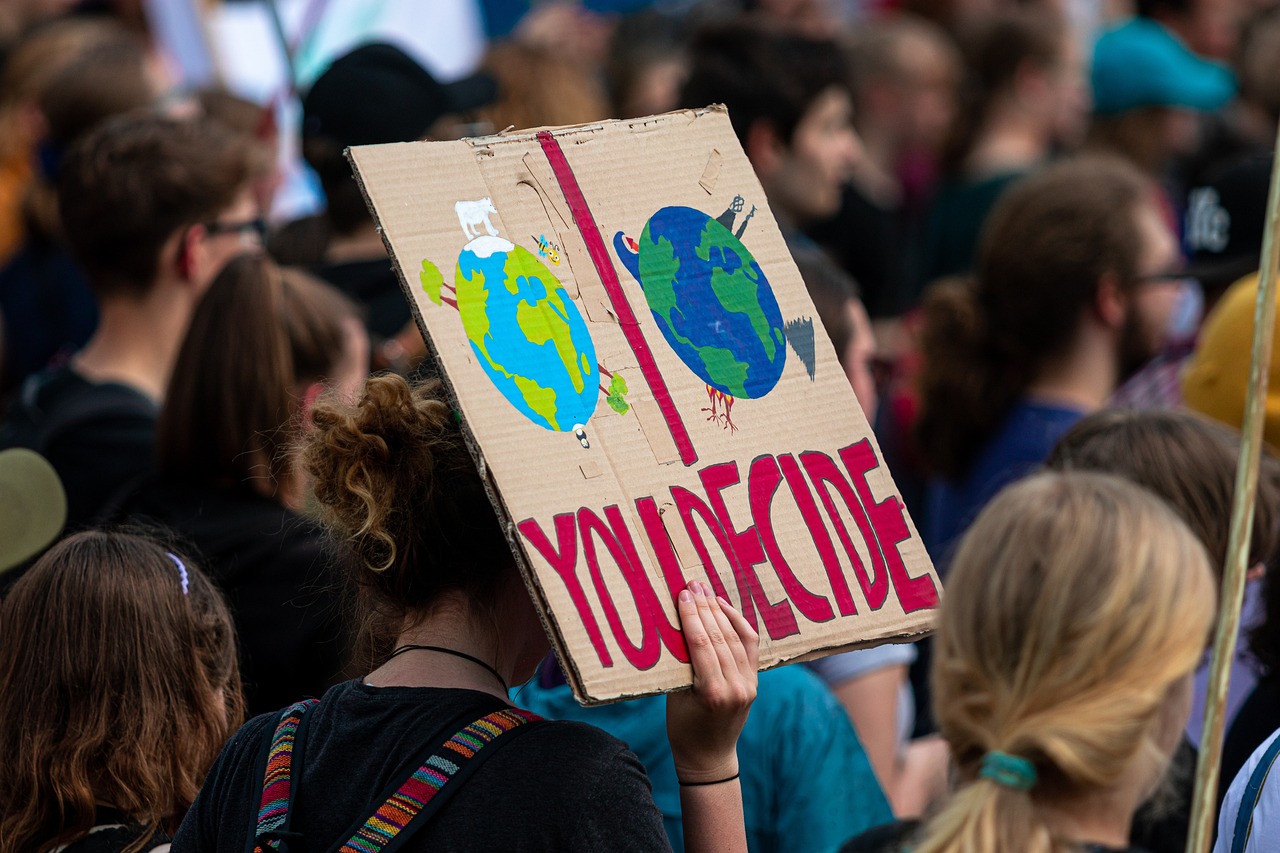Das Bild zeigt Jugendliche mit einem Klimademonstrationsschild mit dem Schriftzug "You decide"