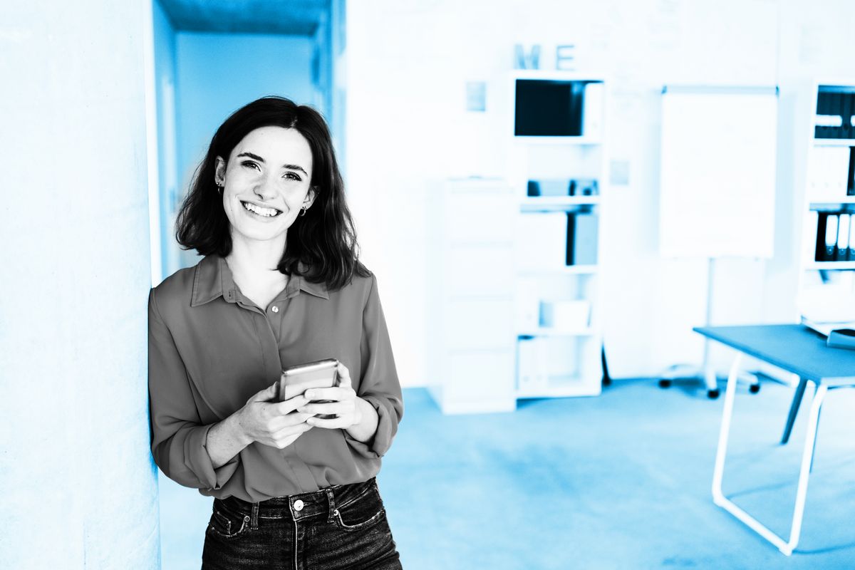 young modern business woman with cell phone laughs at camera